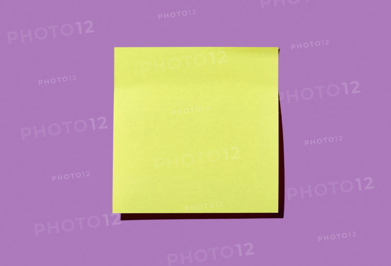 Blank yellow post it note on purple background