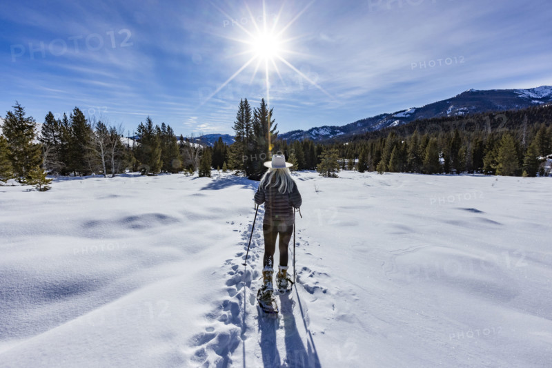 USA, Idaho, Sun Valley, Rear view of woman snowshoeing on sunny winter day