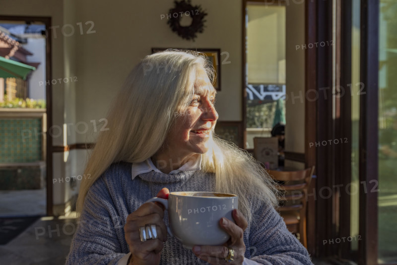 Portrait of smiling senior woman holding mug of coffee at home