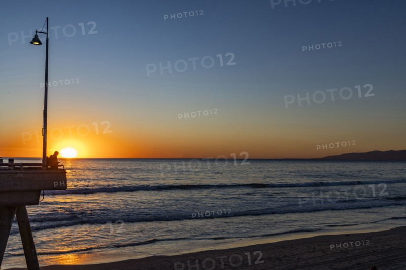 USA, California, Venice, Sun setting above calm ocean and Venice Pier