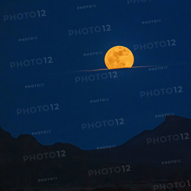 Pink Moon rising over cloud bank. Bellevue, Idaho, USA.