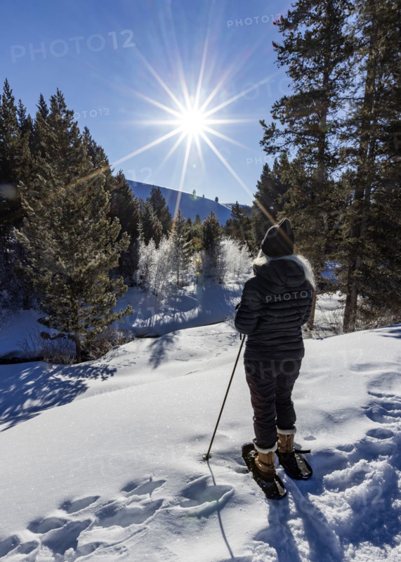 Rear view of woman snowshoeing in landscape on sunny day. Sun Valley, Idaho, USA.