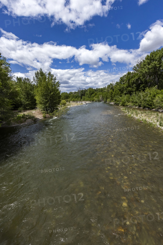 White puffy clouds above Big Wood River . Bellevue, Idaho, USA.