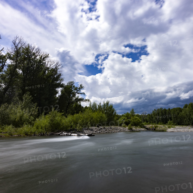 Clouds above motion blurred Big Wood River. Bellevue, Idaho, USA.