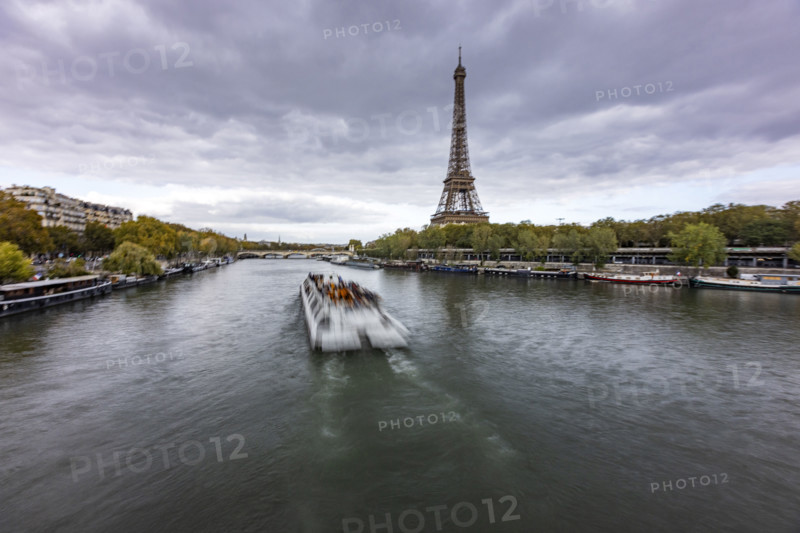 Sightseeing boat along Seine river with Eiffel Tower in background. Paris, Ile de France, France.