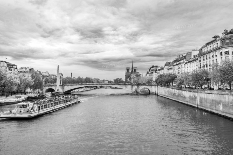 Sightseeing boat on Seine River at Ile Saint-Louis, black and white. Paris, Ile de France, France.