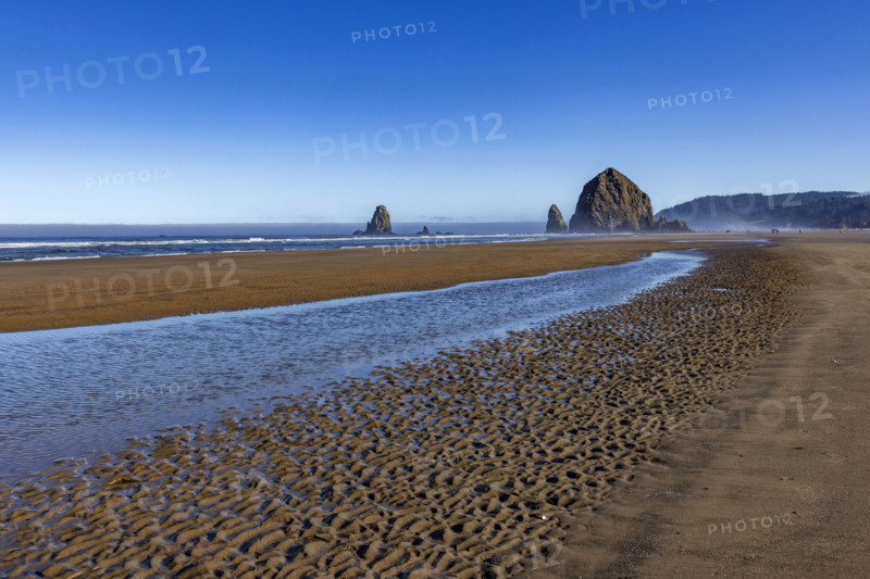 Cannon Beach at low tide with Haystack Rock in background. , Oregon, USA.