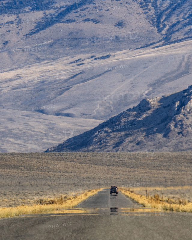 Lone vehicle on rural road over Trail Creek Pass. Mackay, Idaho, USA.