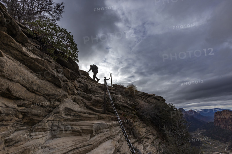 Low angle view of female hiker climbing top of Angels Landing. , Utah, USA.