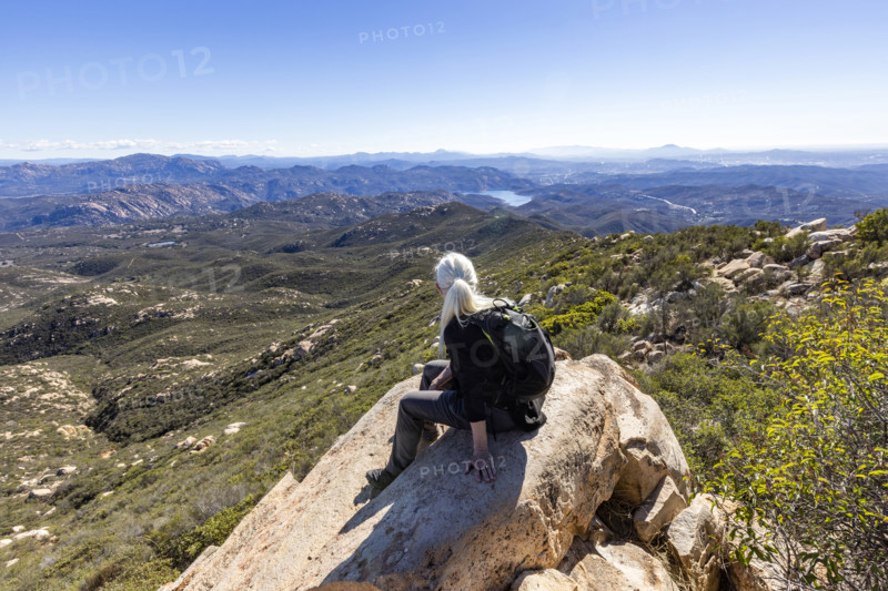 Senior blond hiker looking at view from top of Iron Mountain. Temecula, California, USA.