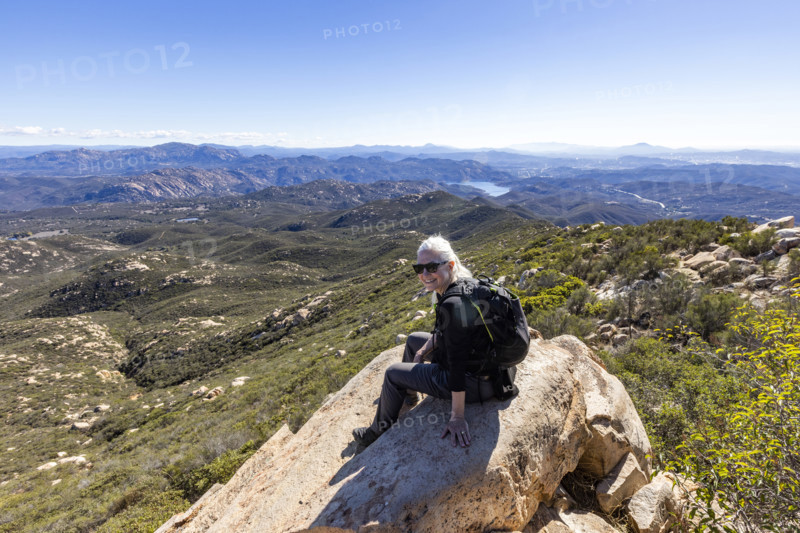 Senior blond hiker looking at view from top of Iron Mountain. Temecula, California, USA.