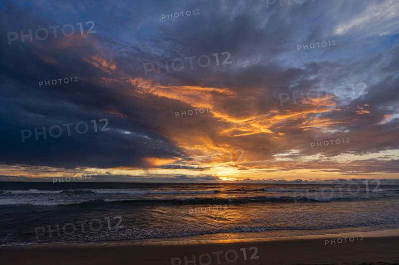 Sun setting above calm sea and Playa Grande. , Guanacaste, Costa Rica.