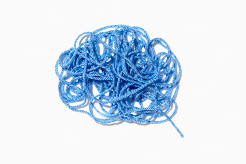 Tangled blue yarn on white background. New York City, New York State, USA.