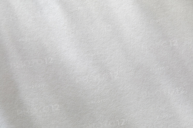 Dappled light on textured white paper. New York City, New York State, USA.