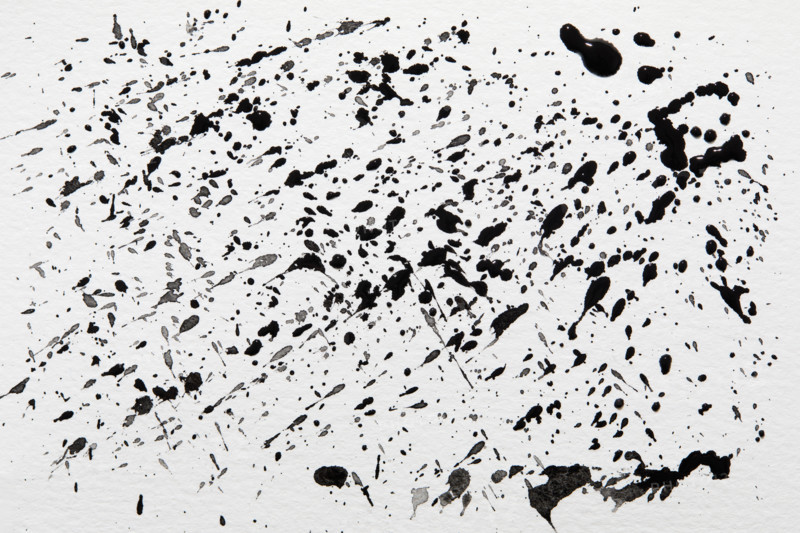 Black paint spatter on white background. New York City, New York State, USA.
