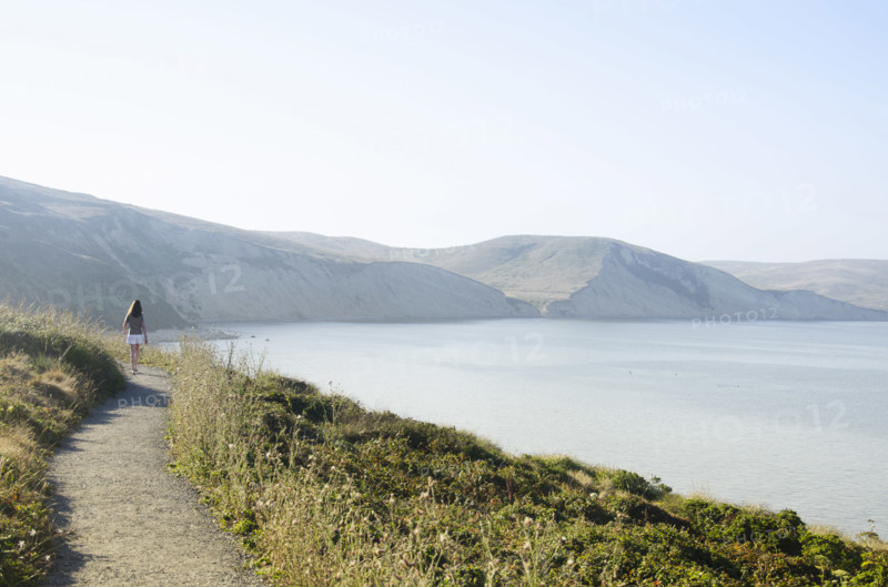 Rear view of woman on path at Drakes Bay, Inverness, California, USA.