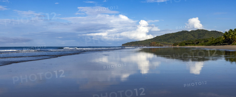Sky and clouds reflecting in calm sea surface at dawn, Playa Grande, Guanacaste, Costa Rica.