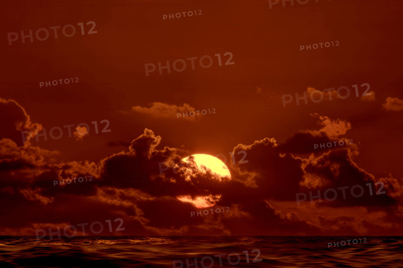 Sun rising through clouds over Atlantic Ocean, Boca Raton, Florida, USA.