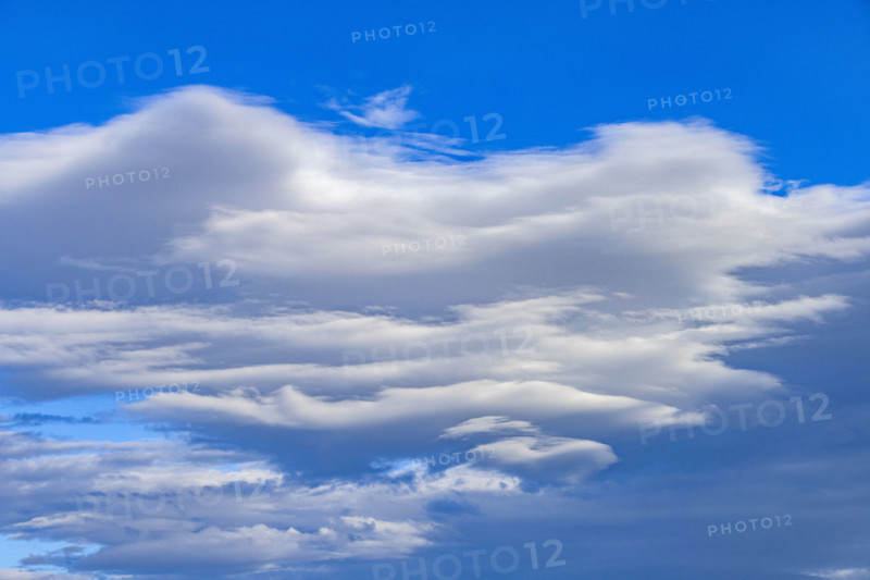 White lenticular clouds on blue sky