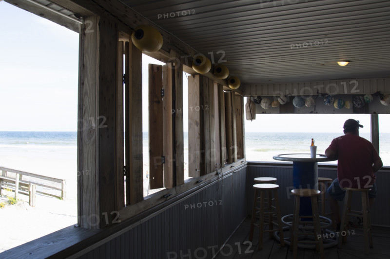 Rear view of man relaxing in seaside bar