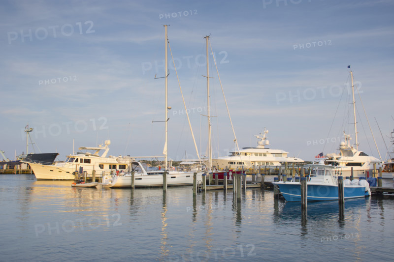 Boats moored at harbor at sunset