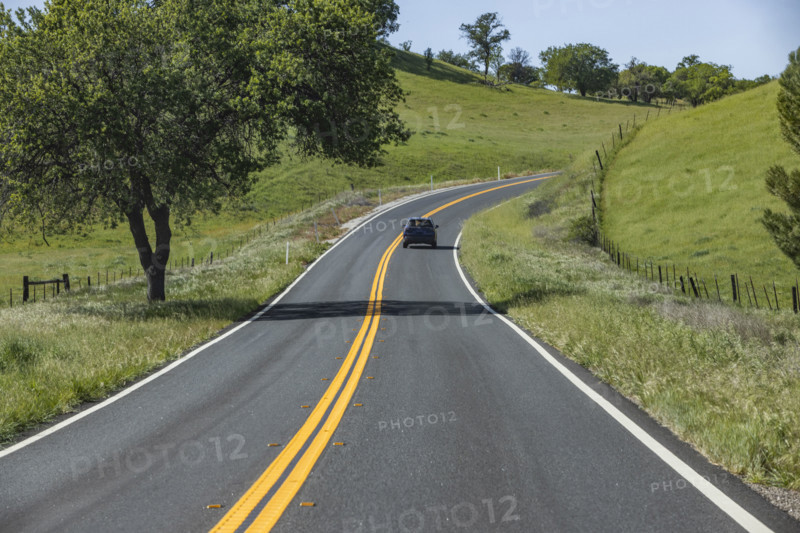 Empty road through green hills