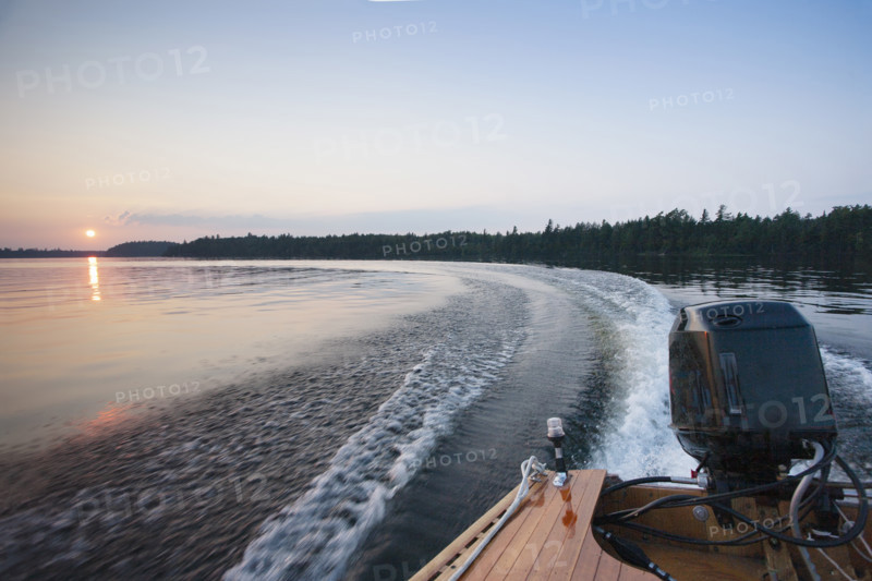 Motorboat wake on Saranac Lake at sunset
