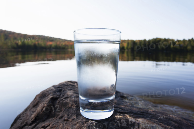 Glass of pure cold spring water by Northern Lake