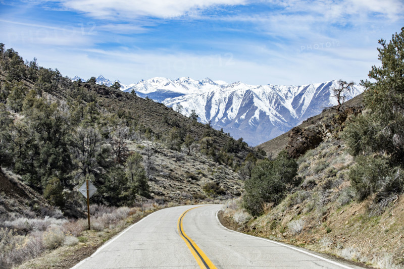 Empty two-lane highway through desert to mountains