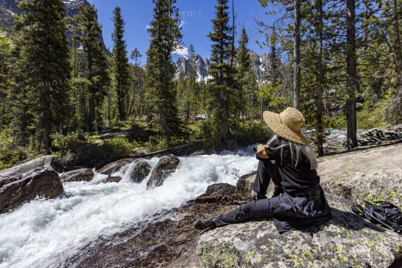Senior woman resting on rock in Sawtooth Mountains