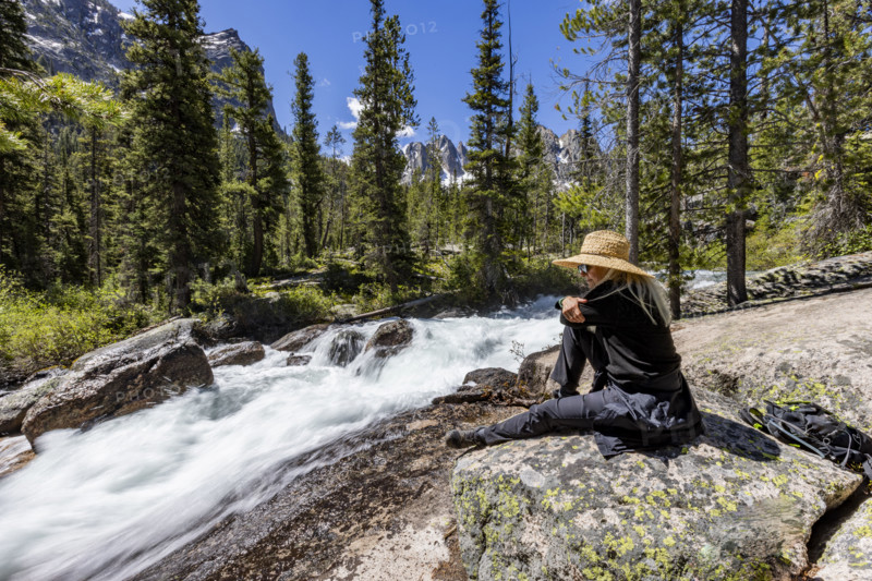Senior woman resting on rock in Sawtooth Mountains
