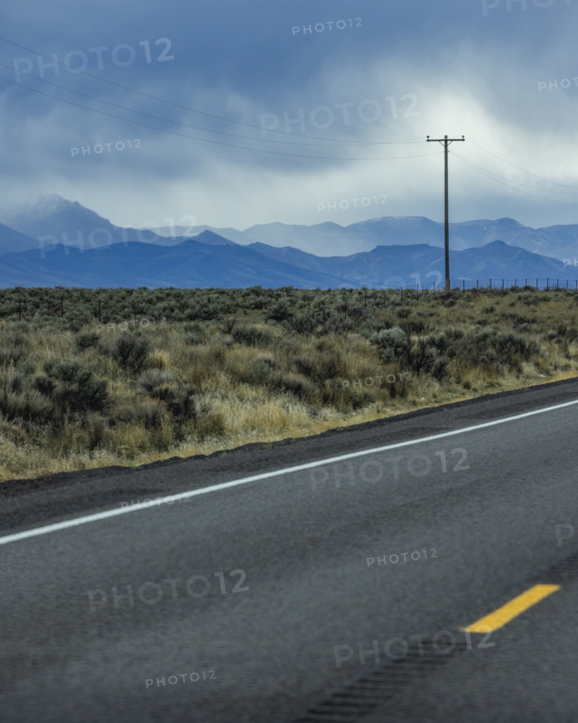 Dramatic sky above empty highway and mountains