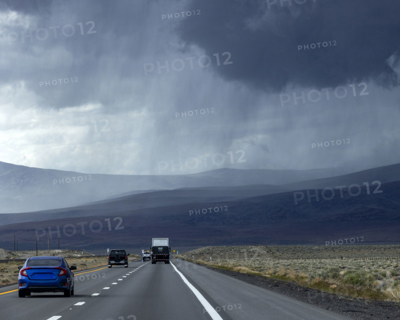Storm clouds and rain above desert highway