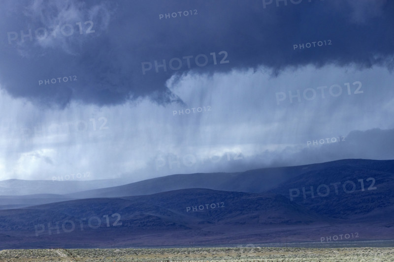 Storm clouds and rain above hills