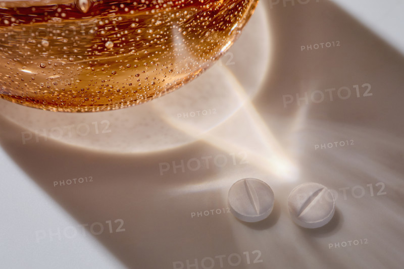 Water glass and two white pills