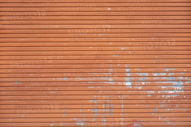 Close-up of old orange metal door