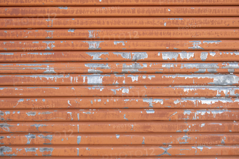 Close-up of old orange metal door