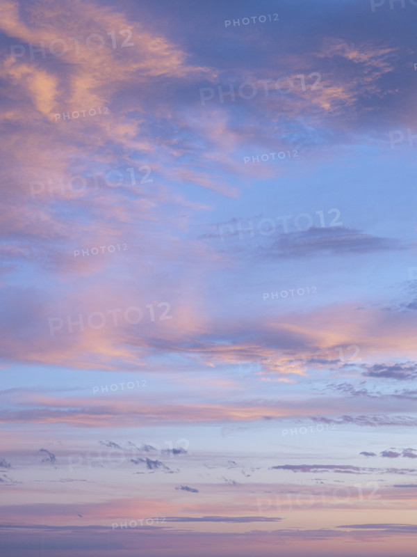 Pale pink clouds against blue sky