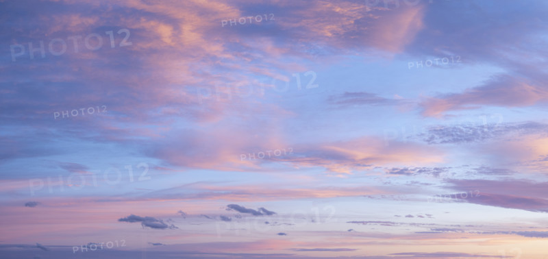 Pale pink clouds against blue sky