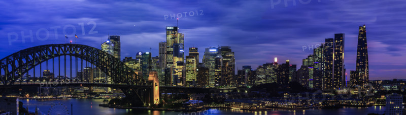 Panoramic view of Sydney CBD and Harbour Bridge illuminated at night