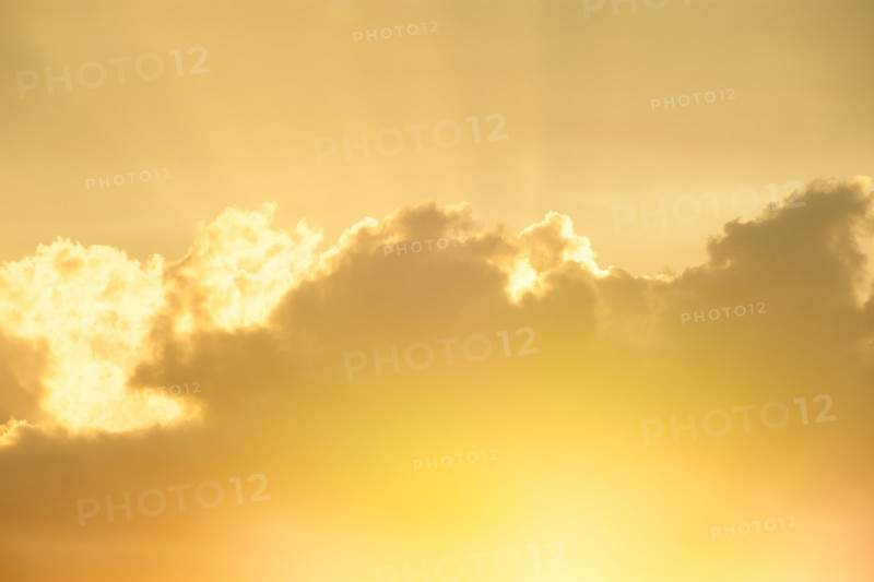Setting sun shining through gold clouds
