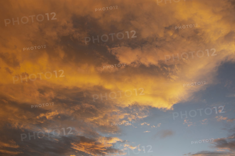 Storm clouds colored by setting sun