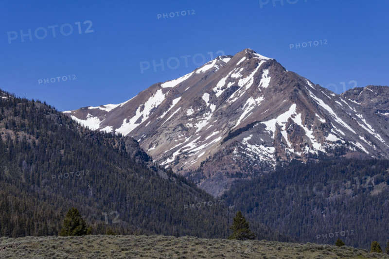 Forested hills and mountain with remnants of snow