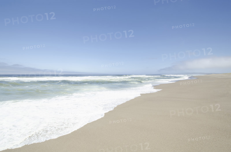 Ocean surf on calm empty beach