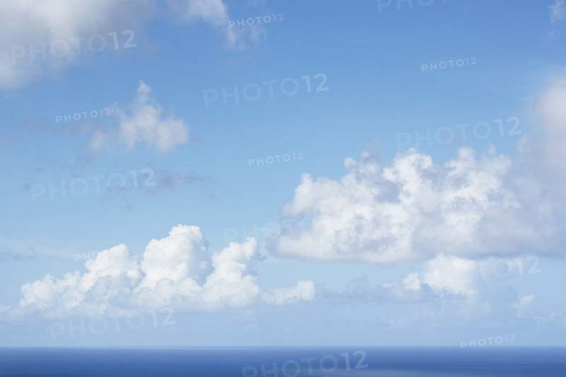 White puffy clouds above calm Caribbean Sea