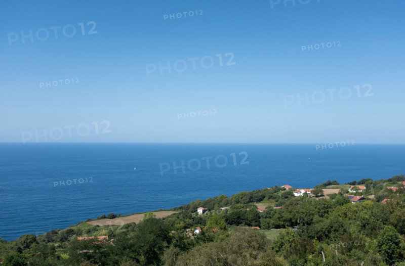 Clear sky over calm sea and green hill. San Sebastian, Gipuzkoa, Spain