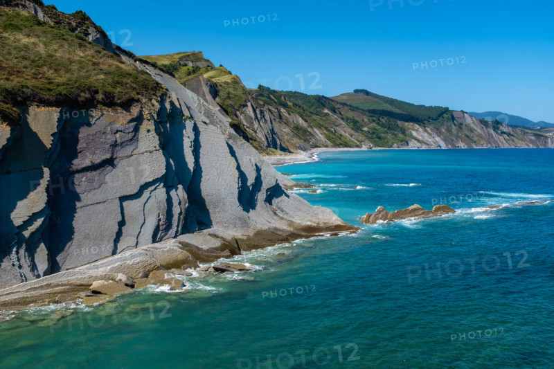 Cliffs and turquoise sea on sunny day. Zumaia, Gipuzkoa, Spain