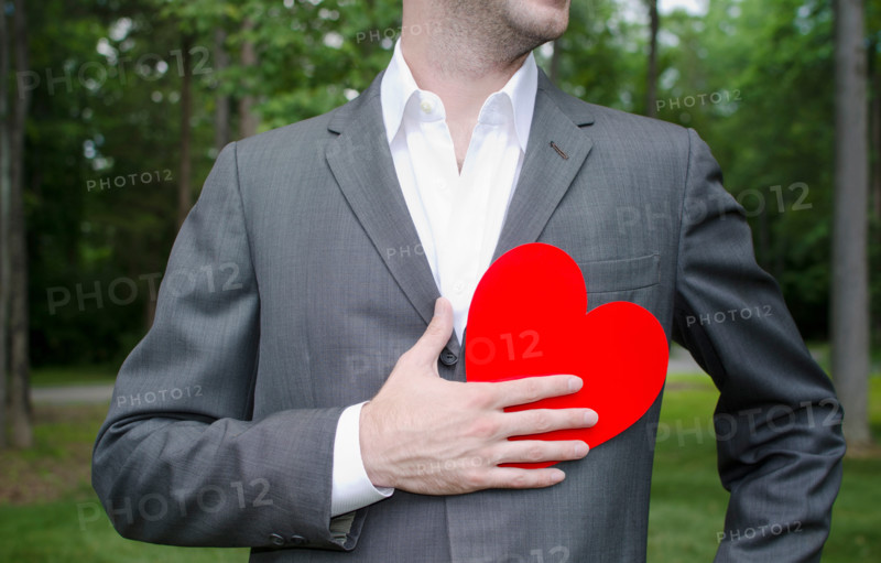 Mid section of man with red paper heart in hand. Mendham, New Jersey, United States
