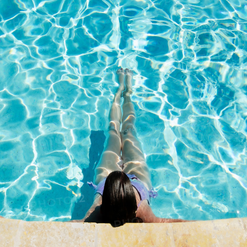 Overhead view of woman relaxing in swimming pool. St. John, United States Virgin Islands, United States