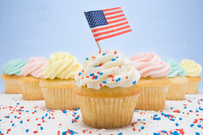 Studio shot of patriotic cup cakes with colorful sprinkles and American flag. Mendham, New Jersey, United States